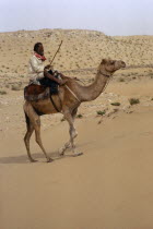 Bedouin man riding camel in the desertMale Men Guy Middle East One individual Solo Lone Solitary Qatari