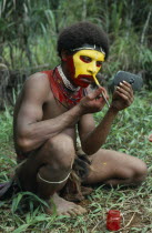 Huli tribesman painting his face using old car wing mirror to see his reflection.Automobile Africa Automotive Automvil Cars Guinee Motorcar One individual Solo Lone Solitary Reflexion