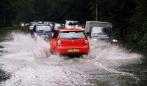 Cars driving through flash floods in Sevenoaks Kent.European  Flood Automobiles Autos Holidaymakers Tourism Tourist