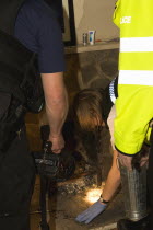 Police searching through fire embers for signs of drug use during drugs raid on residential home.European  European