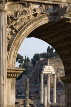 The three Corinthian columns of the Temple of Castor and Pollux and the walls of the Palatine seen through the Arch of Septimius Severus in the ForumEuropean Italia Italian Roma Southern Europe 3 His...