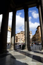 Piazza della Rotonda seen through the granite columns of the Pantheon with tourists walking in the squareEuropean Italia Italian Roma Southern Europe Gray History Holidaymakers Religion Religious Tou...