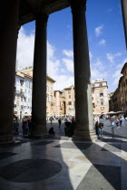 Piazza della Rotonda seen through the granite columns of the Pantheon with tourists walking in the squareEuropean Italia Italian Roma Southern Europe History Holidaymakers Religion Religious Tourism