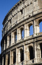 Detail of The Colosseum amphitheatre exterior with tourists walking past built by Emperor Vespasian in AD 80 in the grounds of Domus Aurea the home of Emperor NeroEuropean Italia Italian Roma Souther...