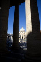 Vatican City The Basilica of St Peter and the square or Piazza San Pietro with tourists seen through the columns of BerniniEuropean Italia Italian Roma Southern Europe Catholic Principality Citta del...