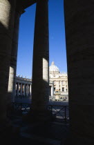 Vatican City The Basilica of St Peter and the square or Piazza San Pietro with tourists seen through the columns of BerniniEuropean Italia Italian Roma Southern Europe Catholic Principality Citta del...
