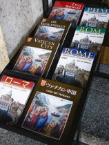 Display of guide books to the city and the Vatican in different languagesEuropean Italia Italian Roma Southern Europe Catholic Principality Citta del Vaticano Gray Papal Religion Religious