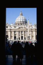 Vatican City Silhouette of tourists passing through an arch leading to the Piazza San Pietro or St Peters Sqaure with the Basilica of St Peter beyondEuropean Italia Italian Roma Southern Europe Catho...