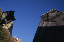 The Net Shops. Tall black wooden huts used for storing fishing nets. Funicular railway behind.European Great Britain United Kingdom Northern Europe UK