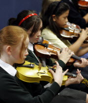 School orchestra  girls playing violins pizzicato style.European Immature Kids Learning Lessons Performance Teaching Public Presentation Young Unripe Unripened Green