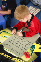 Two young left handed boys on Christmas Eve sitting down on a sofa and writing their Santa Lists at tablesCultural Cultures Immature Kids Order Fellowship Guild Club Religious West Indies Xmas Christ...