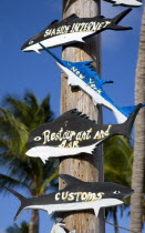Wooden signs in the shape of different fish on a post at The Anchorage Yacht Club in Clifton Harbour pointing to the internet cafe  restaurant and customsCaribbean West Indies Windward Islands Bar Bi...