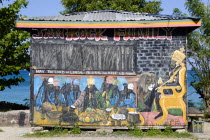 Colourful Rastafarian food hut called Jam Rock Cafe on the beach in Hillsborough decorated with a Rastafarian Last Supper and Emperor Haile Selassie painted on it and the words May The Lord of Lords B...