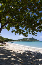 The calm clear blue water breaking on Paradise Beach in LEsterre Bay with Cistern Point in the distance. A small number of people on the beach and in the waterCaribbean Grenadian Greneda West Indies...