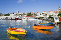 Water taxi boats moored in the Carenage harbour of the capital city of St Georges with houses and the roofless cathedral damaged in Hurrican Ivan on the nearby hillCaribbean Grenadian Greneda West In...