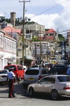 Male corporal of the Royal Grenadian Police Force directs traffic in busy Market Street in the capital city of St GeorgesCaribbean Grenadian Greneda West Indies Grenada Ecology Entorno Environmental...
