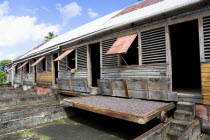 Cocoa beans drying in the sun on retractable racks under the drying sheds at Dougaldston Estate plantation Caribbean Grenadian Greneda West Indies Grenada Farming Agraian Agricultural Growing Husband...