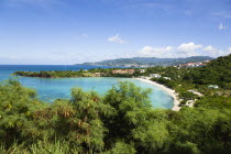 The aquamarine sea and tree lined white sand of BBC Beach in Morne Rouge Bay with the capital city of St Georges in the distanceCaribbean Grenadian Greneda West Indies Grenada Beaches Resort Sandy Sc...