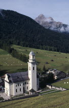 The village church of Sesto in the Val di Sesto set below forested hills and snow capped mountainsItalia Italian Religion Southern Europe European Religious Scenic