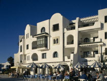 Villas in an Arab style. Tourists sitting at tables outside cafe on cobbled streetAfrican Arabic Bar Bistro Holidaymakers Middle East North Africa Restaurant Tourism Inn Northern Pub Tavern