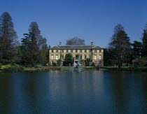 View over lake towards large house and fountains with visitors sitting on the banks.European Great Britain Londres Northern Europe UK United Kingdom