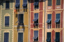 Green yellow and red painted buildings with blue shutters by the harbourItalia Italian Southern Europe European