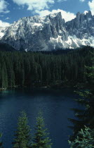 Conifer trees lining Lake Carezza below Mount LatemarItalia Italian Southern Europe European Scenic