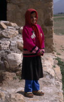 Qashqai nomad young girl in red and white spotted headscarf.  Standing with hands clasped in front of her.Immature Iranian Kids Middle East One individual Solo Lone Solitary