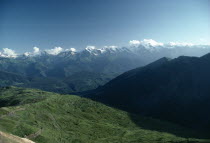 Mountain landscape with distant snow covered peaks and dense forest on lower slopes.Former Soviet State Asian European Georgian Sakartvelo Scenic Western Asia