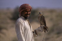 Bedouin man holding falcon on his wrist.Arabian Male Men Guy Middle East One individual Solo Lone Solitary 1 Male Man Guy Single unitary
