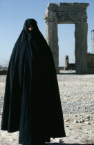 Full length standing portrait of a woman wearing a black Chador at PersepolisChadarChadoorTakhte Jamshid Female Women Girl Lady Iranian Middle East One individual Solo Lone Solitary Religious