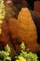 Evening light on rock face in the Belvedere Panorama area part framed by tree tops.Ochre Trail European French Western Europe Warm Light