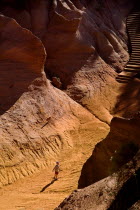 Small boy playing on sandy path through eroded  ochre landscape in the Belvedere Panorama area Ochre Trail European French Western Europe