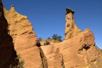 Colorado Provencal.  Cheminee de Fee or Fairy Chimneys.  Capped  eroded  ochre rock pinnacle  angled view against blue sky from park trail Ochre Trail European French Western Europe