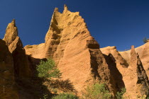 Colorado Provencal.  Cheminee de Fee or Fairy Chimneys.  Looking up eroded ochre cliff face topped with jagged peaks from park trail below.Ochre Trail European French Western Europe
