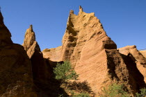 Colorado Provencal.  Cheminee de Fee or Fairy Chimneys.  Looking up eroded ochre cliff face topped by jagged peaks from park trail below.Ochre Trail European French Western Europe