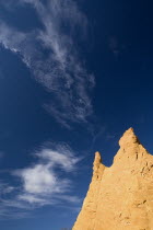 Colorado Provencal.  Cheminee de Fee or Fairy Chimneys.  Dramatic sky with high  windswept clouds over jagged peak of ochre rock.Ochre Trail European French Western Europe Blue