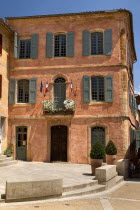 Roussillon.  Exterior facade of building with typical ochre coloured walls and painted window shutters. European French Western Europe
