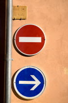Roussillon.  Prohibitive and directional road signs on ochre coloured wall in the town square.European French Western Europe