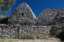 Le Village des Bories.  Primitive village comprising of mortarless  stone  beehive shaped huts or bories each with a specific purpose.  Back of barn from Prov 137 with a dwelling house on the left.Eu...