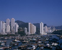 Aberdeen harbour and typhoon shelter.  Junks  houseboats  fishing boats and other vessels with high rise city buildings beyond.Asia Asian Chinese Chungkuo Jhonggu Zhonggu