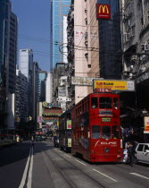 Hong kong Island trams on city street with high rise buildings and advertising hoardings and McDonalds sign overhead.  Asia Asian Chinese Chungkuo Jhonggu Zhonggu