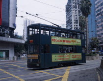 Hong kong Island tram with advertising printed along side and high rise buildings behind.Asia Asian Chinese Chungkuo Jhonggu Zhonggu
