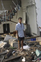 Tsunami. A man stands outside of what is left of his house and tries to salvage what he can from the damage caused by the tsunami  nothing is left standing in the village. 2500 people are pressumed de...