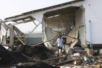 Tsunami. A man stands outside of what is left of his house and tries to salvage what he can from the damage caused by the tsunami  nothing is left standing in the village 2500 people are pressumed dea...