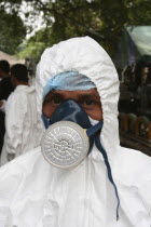 Tsunami. Forensic people and volunteers have to wear masks and suits to work in the area where the bodies are kept for DNA testing for the sanitation  They are also sprayed down when leaving the area....