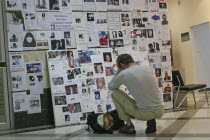 Tsunami. A french tourist grieves while looking at pictures of french people missing along with hundereds of others posted up at the Bangkok Phuket hospital  on the 5th Jan.Asian Ecology Entorno Envi...