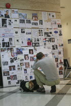 Tsunami. A french tourist grieves while looking at pictures of french people missing along with hundereds of others posted up at the Bangkok Phuket hospital  on the 5th Jan.Asian Ecology Entorno Envi...
