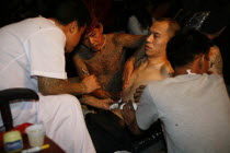 Man having tattoo applied to torso.Asian Southern Ecology Entorno Environmental Environnement Green Issues Male Men Guy Prathet Thai Raja Anachakra Thai Siam Southeast Asia