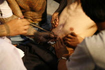 Man having tattoo applied to torso.Asian Southern Ecology Entorno Environmental Environnement Green Issues Male Men Guy Prathet Thai Raja Anachakra Thai Siam Southeast Asia